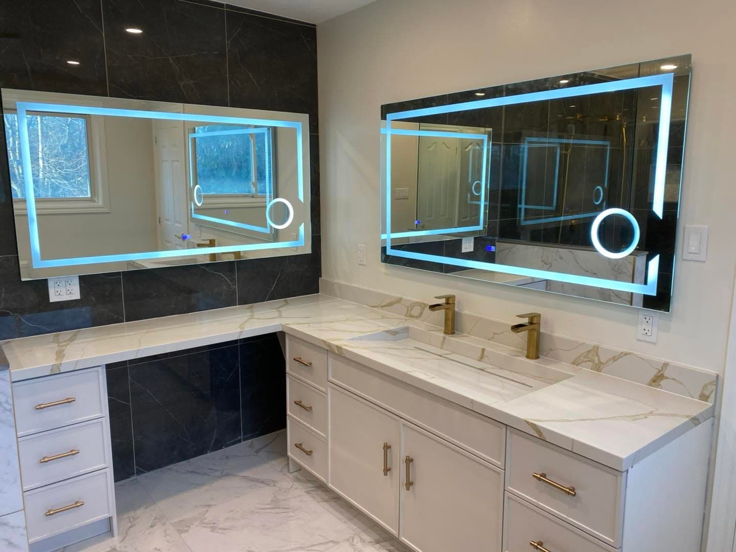 Marble primary bathroom with dual floating vanity and LED mirrors