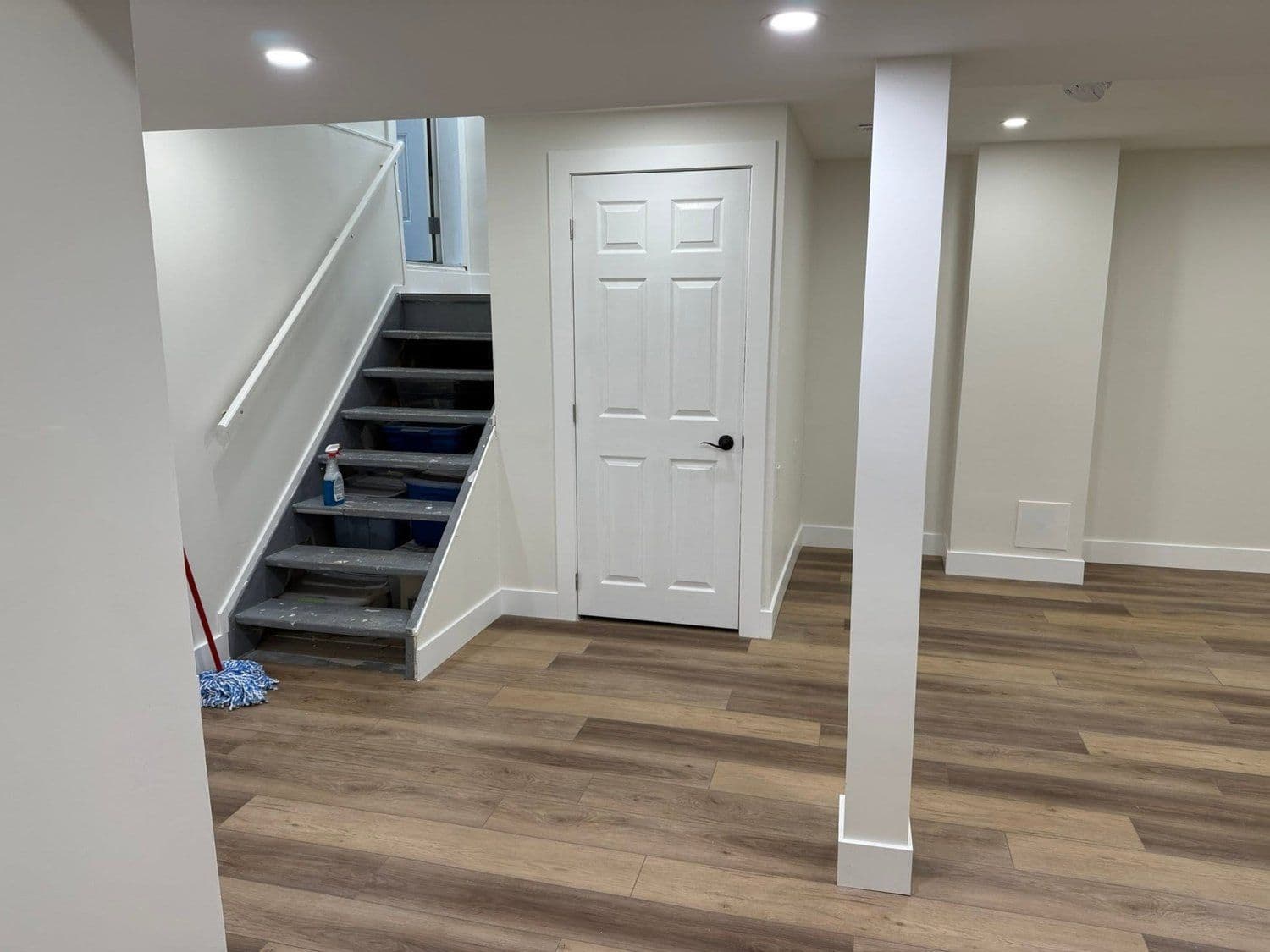Newly finished basement with staircase and vinyl plank flooring