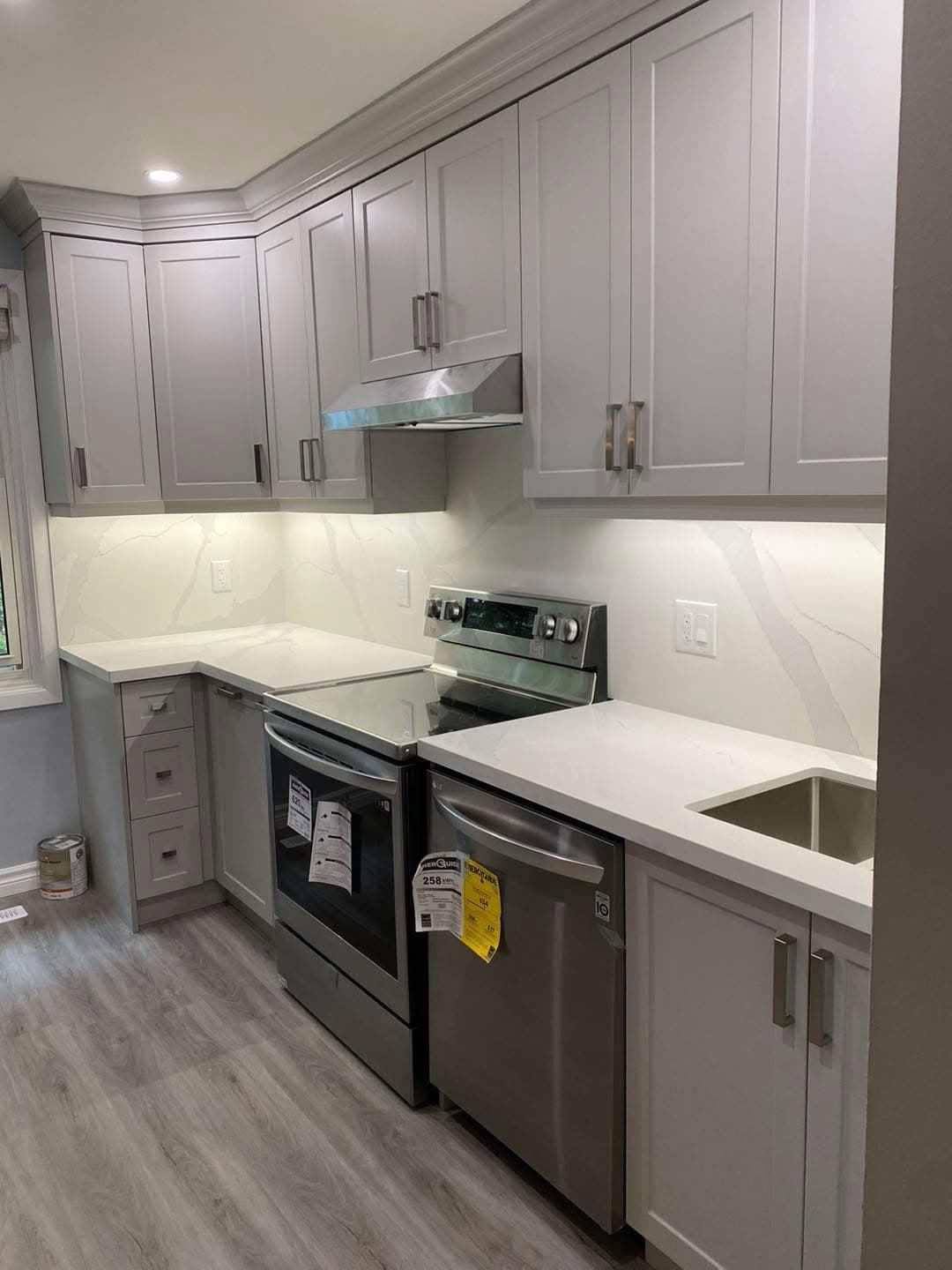 Bright renovated kitchen with white cabinetry and stainless appliances